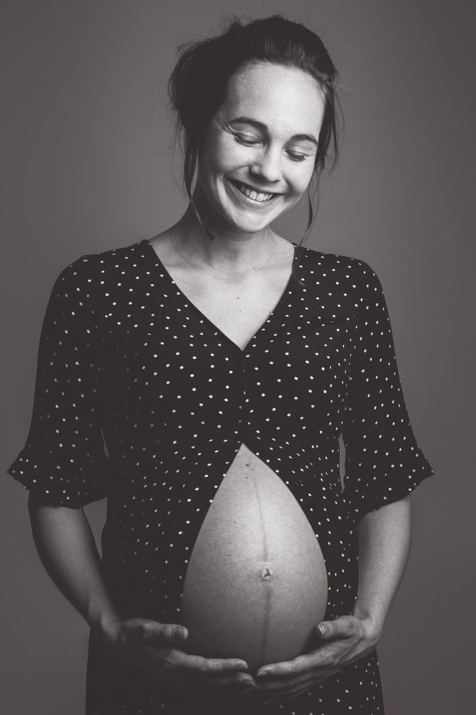 ung och glad mamma gravidfotograferas i göteborg